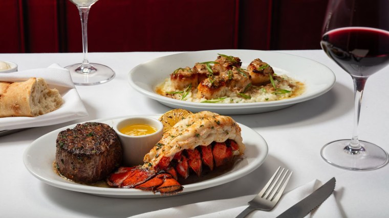 Steak and lobster meal with red wine on white table cloth at Ruth's Chris Steakhouse